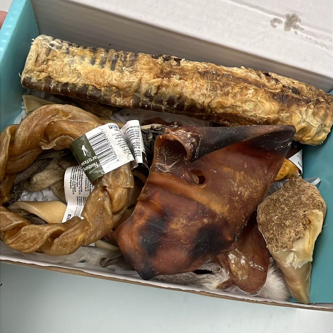 Box containing dried animal bones and hides on a white background