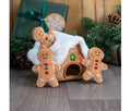 Ancol Gingerbread Snuffle House dog toy: a brown fabric house with a fluffy white roof and front opening, pictured with three gingerbread figures beside Christmas presents.
