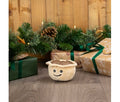 Ancol Mini Matty Mince Pie dog toy with a small cream-coloured pie body, brown top and smiling face, standing in front of Christmas presents.