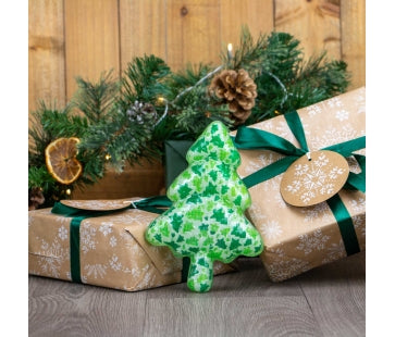 Ancol Squeaky Christmas Tree dog toy with a green festive pattern and short trunk, leaning against a wrapped Christmas present.