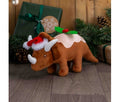 Ancol Dex the Dino Christmas Pudding dog toy: a brown plush horned dinosaur wearing a red hat, with a pudding-style icing and holly decoration on its back.