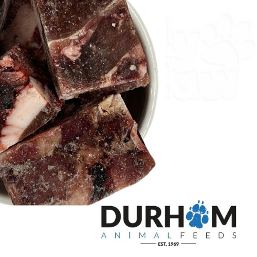 Frozen venison chunks in a bowl beside the Durham Animal Feeds logo.